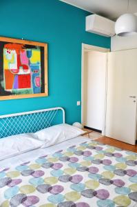 米兰Tortona86的卧室配有一张床,墙上挂有绘画作品