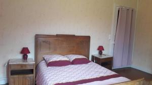 FaucompierreLE REVE DE CHARLES的一间卧室配有一张床和两张带台灯的桌子。