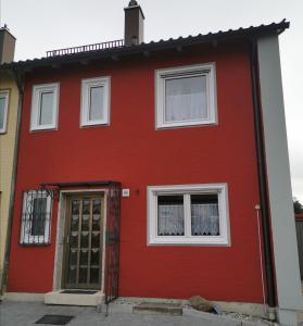 考夫博伊伦Ferienhaus CasaNoWa的红色的房子,有门和两个窗户