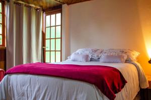 Núcleo MauáChalés Luz da Montanha的一间卧室配有一张大床和紫色毯子