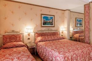 梅斯特威尼斯酒店的酒店客房设有两张床和两盏灯。
