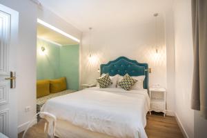塞萨洛尼基Bahar Boutique Hotel的一间卧室配有一张白色大床和蓝色床头板