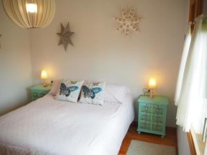 阿尔普Cozy Apartment in Alp的一间卧室配有白色的床和两张蓝色的桌子