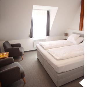 滨湖波德斯多夫Haus56的卧室配有床、椅子和窗户。