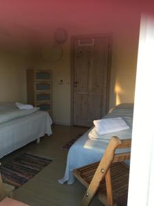 FarsøMargretelyst的一间卧室设有两张单人床和一扇门