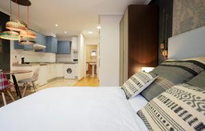 奥维多DE LA GUARDIA LOFT ROSAL的一间带白色床的卧室和一间厨房