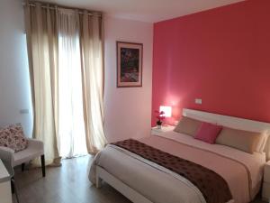 孔韦尔萨诺Dimora Francesca的一间卧室设有一张大床和红色的墙壁