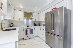 沃恩Luxury Adventure, Rutherford Go station & Wonderland的厨房配有白色橱柜和不锈钢冰箱