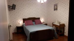 圣梅尔埃格利斯Chambres d'Hôtes et Table d'Hôtes- Valentine 44的一间卧室配有一张带两个粉红色枕头的床
