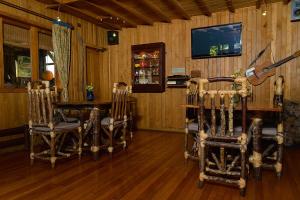 巴拉斯港Casa Azul Hostel的一间带桌椅和电视的用餐室