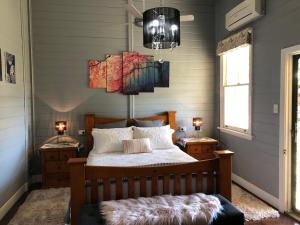 Pee DeeBellbrook Historic Getaway at Bellmeadow Homestead的一间卧室配有一张床和一个吊灯