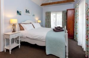 泰晤士库拉努伊度假屋的卧室设有一张白色大床和一扇窗户。