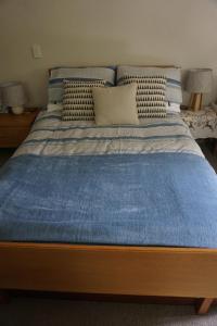格雷敦Ivy's Cottage的一张带蓝色毯子和枕头的床