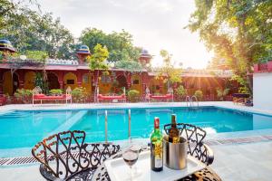 奥拉奇哈河滨布恩德尔克汉德酒店的游泳池旁的桌子上摆放着葡萄酒瓶