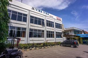 LhokseumaweOYO 2180 Vina Vira Hotel的前面有停车位的建筑