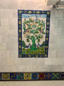 斋浦尔Jaipur Haveli的镶嵌在墙上的马赛克瓷砖墙,上面有树