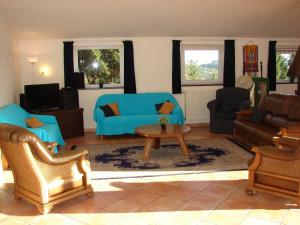 比林根Oberes Ourtal Lodge的客厅配有蓝色的沙发和桌子