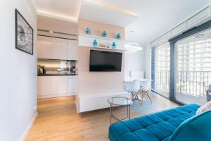 米兹多洛杰Horyzont 415的一间带蓝色沙发的客厅和一间厨房