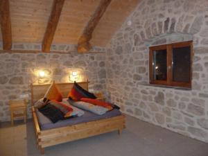 TenceBellevue Chambres d'hôtes的石墙房间内的一张床位
