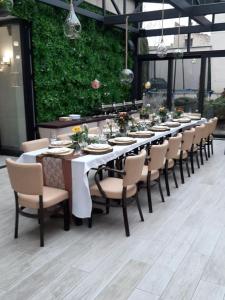科马尔诺立托维尔酒店的一张长桌子,上面有椅子和盘子