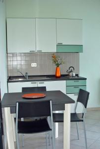 韦尔巴尼亚Tre ponti monolocale的厨房配有桌子、两把椅子和台面