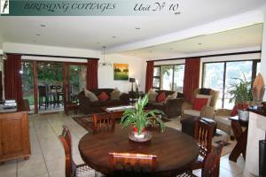 香槟谷Birdsong Cottages - 10 Poplar Drive - Bergview Estate的客厅配有木桌和椅子