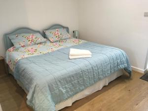 WhitegateElm Cottage Touring Park的一间卧室配有一张带蓝色毯子和枕头的床。