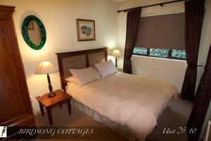 香槟谷Birdsong Cottages - 10 Poplar Drive - Bergview Estate的卧室配有白色的床和窗户。