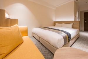 大阪IAM HOTEL的酒店客房,设有两张床和一张沙发