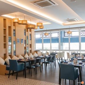 清莱Grand Vista Hotel Chiangrai-SHA Extra Plus的用餐室设有桌椅和窗户。