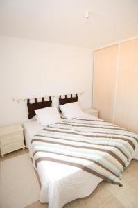吉索纳恰艾斯托纳别墅的白色卧室配有带条纹床单的大床