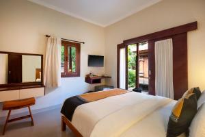 沙努尔巴厘岛尼撒沙努尔酒店的一间卧室设有一张大床和一个窗户。
