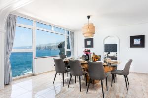 拉克鲁斯Ocean Vistas 24的一间带桌椅和大窗户的用餐室