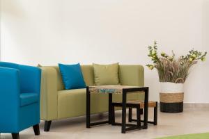 米兹多洛杰Aquamarina Onyx Marina Invest的绿色沙发、桌子和蓝色椅子