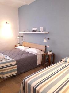 奥尔贝泰洛Affittacamere orbetello centro的一间卧室设有两张床和蓝色的墙壁