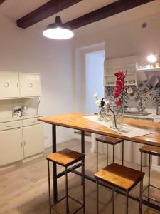 奥尔贝泰洛Affittacamere orbetello centro的厨房配有木桌、椅子和柜台