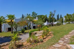 维拉摩拉普拉多高尔夫酒店的棕榈树花园和背景房屋