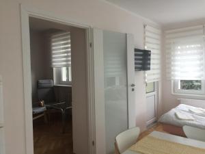 格丁尼亚Apartamenty Przy Plaży Gdynia Orłowo的一间设有一张床的白色卧室和一间带窗户的房间