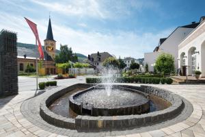 特里滕海姆Gästehaus Moselkloster的庭院中的一个喷泉,有一座教堂