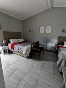 波罗瓜尼Stew s Room的一间带两张床的卧室,铺有瓷砖地板。