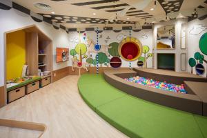大阪Citadines Namba Osaka的一间铺有绿色地板的儿童游戏室和一间游戏室