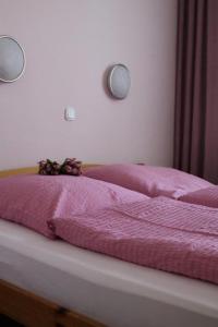 魏登威勒酒店的一张带粉红色毯子和鲜花的床