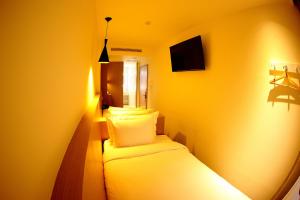 宜兰市26旅店的黄色的小房间,配有床和枕头