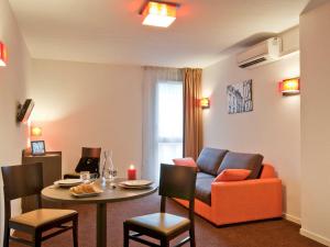 普瓦捷普特瑞斯爱达格公寓式酒店的客厅配有沙发和桌子