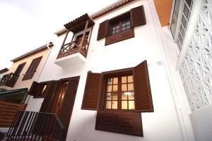 拉奥罗塔瓦Lovely house in the best area of La Orotava的白色的建筑,设有棕色的门窗