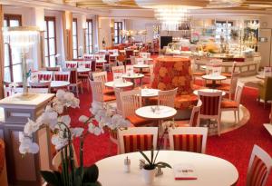 魏登Das Brunners的一间设有白色桌椅和鲜花的餐厅