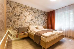 索非亚SCA Sofia City Apartments的一间卧室配有一张带花卉壁纸的床