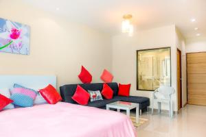 奈通海滩The Nai Thon Condominium Unit的一间卧室配有一张床和一张带红色枕头的沙发