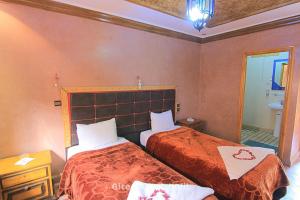 伊姆利尔Gite Ghazal - Atlas Mountains Hotel的酒店客房,设有两张床和镜子