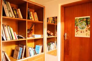 班加罗尔BE ANIMAL Hostel的书架上装满了书,放在门边